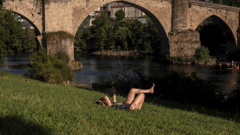 Una mujer disfruta este martes de las altas temperaturas en el entorno del río Miño