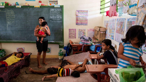 11/06/2023 - Elena Rosales, de 23 años, sostiene a su hija dentro de un aula convertida en un sitio de evacuación tras el aumento del nivel de alerta del volcán Mayon, en Daraga, provincia de Albay, Filipinas, a 11 de junio de 2023.