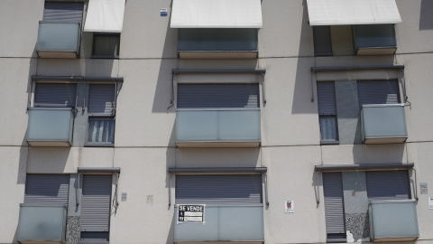 Cartel de se vende en el balcón de un piso de un edificio de Madrid.