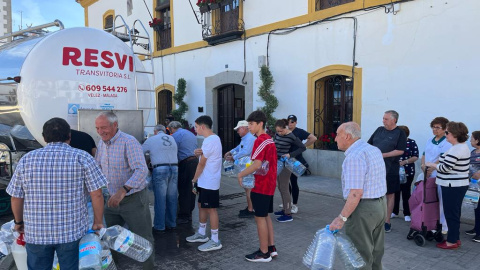 Vecinos de El Viso se acuden al camión cisterna que visita el pueblo para conseguir agua potable.