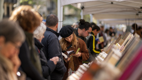 Varias personas miran libros en un puesto durante el día de Sant Jordi 2024, a 23 de abril de 2024, en Barcelona.