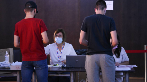 Dos adolescentes en el registro, después de recibir la primera dosis de la vacuna Pfizer en el punto de vacunación de Xátiva, situado en el Hogar de los Jubilados, a 10 de agosto de 2021, en Xátiva, Valencia,