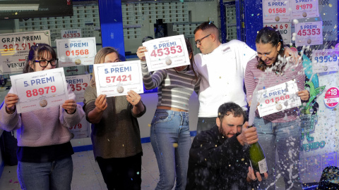 Los propietarios y trabajadores de la administración de lotería Las Arenas de Barcelona, ubicada en el centro comercial del mismo nombre, celebran haber repartido décimos de cuatro distintos quintos premios.