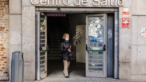 Una mujer sale con mascarilla del Centro de Salud de Lavapiés, a 5 de enero de 2024, en Madrid