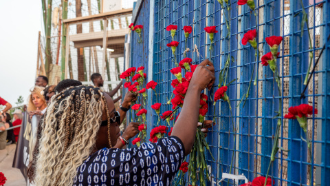 Manifestantes depositan flores en la verja del paso fronterizo de Barrio Chino, epicentro de la tragedia de Melilla del año pasado.