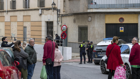 Policías y vecinos frente a la vivienda en Jaén donde este lunes se ha hallado muerto a un niño de 6 años y a su madre en estado grave.