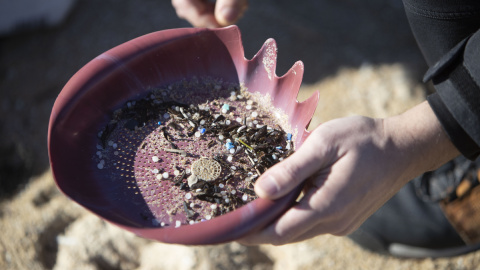 Voluntarios recogen microeplásticos o pellets, que han aparecido en toda la costa atlántica de Galicia, este domingo en la Playa de A Lanzada en O Grove.