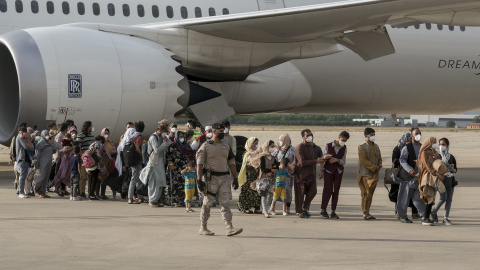 Varias personas, entre ellas niños llegan a la base aérea de Torrejón de Ardoz.