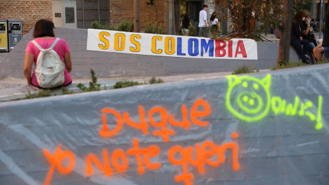 Una pancarta contra el presidente de Colombia, Iván Duque, durante su visita a España, en la plaza Arturo Barea de Lavapiés a 16 de septiembre de 2021, en Madrid