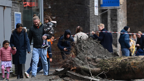 La gente pasa junto a un árbol caído derribado por fuertes vientos durante la tormenta Eunice en Londres, Gran Bretaña, el 18 de febrero de 2022.