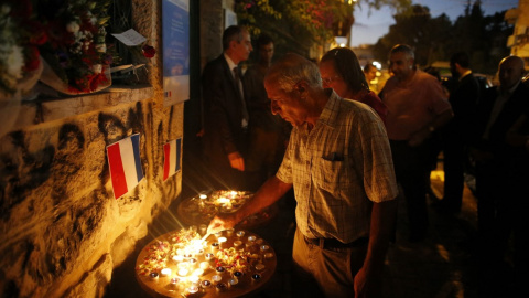 Mordechai Vanunu enciende una vela durante una vigilia en homenaje a las víctimas del ataque mortal en la ciudad de Niza en la Riviera francesa el 18 de julio de 2016.