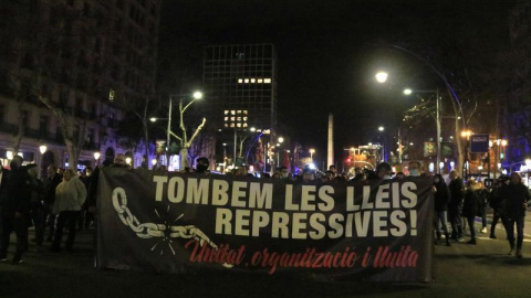 Capçalera de la manifestació 'Tombem les lleis repressives' caminant pel passeig de Gràcia de Barcelona.