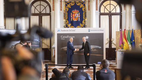 El presidente de Fundación La Caixa, Isidro Fainé(i), y el alcalde de Málaga, Francisco de la Torre(d), junto a la imagen del diseño de la cubierta del futuro CaixaForum de Málaga. EFE/Carlos Díaz.