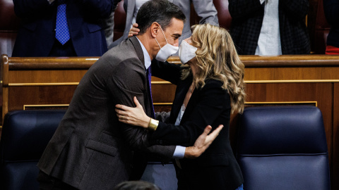 El presidente del Gobierno, Pedro Sánchez (d) y la ministra de Trabajo Yolanda Díaz se abrazan en la sesión plenaria del Congreso de los Diputados el pasado jueves.