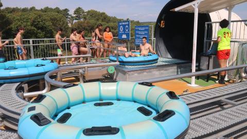 Visitants fent cua i altres ja en un matalàs inflable en una atracció del parc aquàtic Waterworld, a Lloret de Mar.