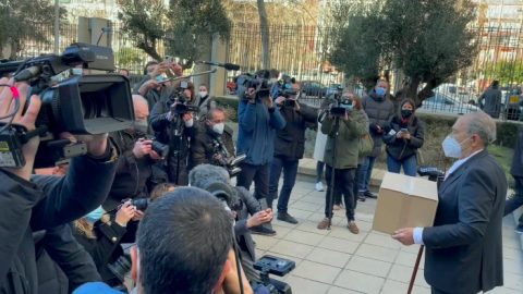 Carlos San Juan con su caja de firmas en el exterior del Ministerio de Economía, y rodeado de periodistas.