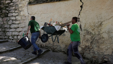 Un par de trabajadores cargan con una carretilla en una calle empinada de la localidad malagueña de Ronda. REUTERS/Jon Nazca