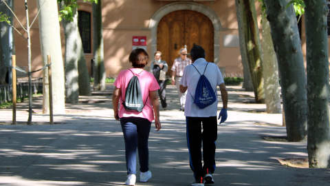 Dues persones grans caminant pel Parc de Can Mercader