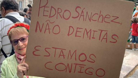 Asistentes a la celebración de los claveles portugueses muestran carteles en apoyo al presidente del Gobierno español, en Lisboa, a 25 de abril de 2024.