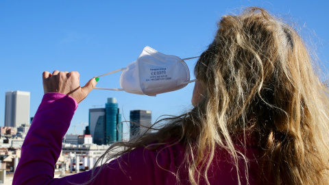 Una mujer se quita la mascarilla, a 8 de febrero de 2022, en Madrid.