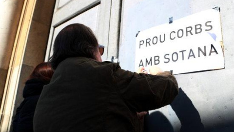 Un home enganxant cartells en la protesta per denunciar els abusos sexuals a menors d'eclesiàstics.