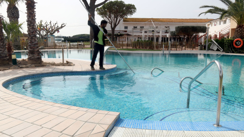 Un treballador netejant la piscina del càmping Les Medes de l'Estartit