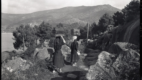 6/5/24 Dos mujeres cargan equipaje sobre sus cabezas desde O Pindo hasta Cee, en A Coruña.