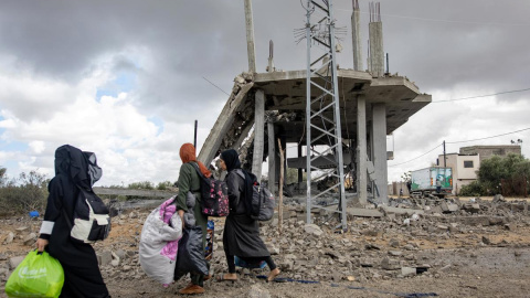 Varias mujeres palestinas caminan descalzas y cargan sus pertenencias después de la orden de evacuación emitida por el Ejército israelí, en Rafah, a 6 de mayo de 2024.