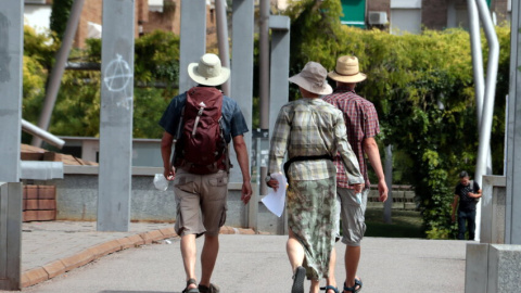 Tres turistes amb el cap cobert amb barrets per la calor, a Lleida.