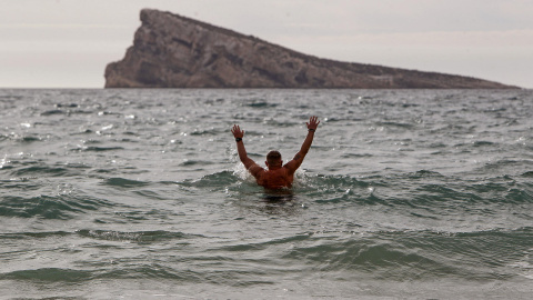 Un hombre se baña en la playa de Levante de Benidorm, en Alacant,  donde las temperaturas llegaron a superar los 25 grados a 18 de enero de 2024.