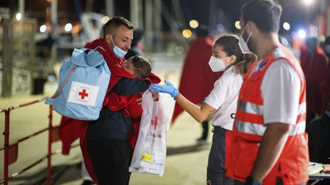 Un hombre acuna en la noche del martes su bebé, de siete meses, en el muelle de Gran Tarajal (Fuerteventura) tras haber sido rescatados.