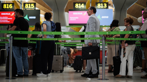 Varios pasajeros en una fila de Iberia en la Terminal T4 del Aeropuerto Adolfo Suárez-Madrid Barajas, a 21 de junio de 2023, en Madrid.