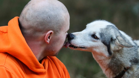 Un perro besa a su dueño.