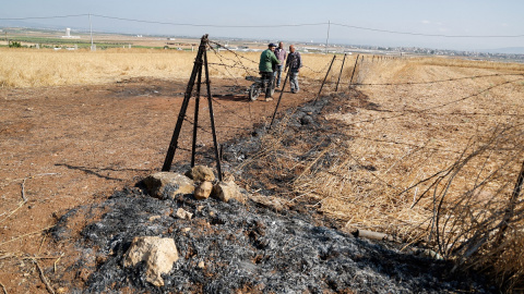 Tres personas observan el lugar donde se ha producido el asesinato selectivo de tres palestinos, en Yenín a 22 de junio de 2023