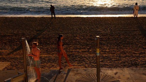 Una persona se ducha en la playa de la Barceloneta, en Barcelona, en mitad de enero.