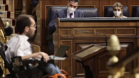 10/11/2021.- El presidente del Gobierno, Pedro Sánchez (c), y la vicepresidenta segunda del Gobierno y ministra de Trabajo, Yolanda Díaz, observan la intervención del portavoz de Unidas Podemos, Pablo Echenique, en una sesión plenaria en el Congreso d