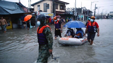 Los equipos de rescate ayudan a un grupo de personas a ponerse a salvo de las inundaciones.