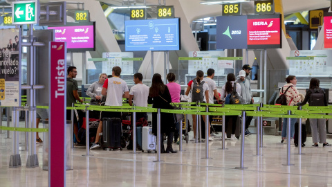 Varias personas en el control de equipaje del aeropuerto Madrid-Barajas, a 5 de diciembre de 2023.