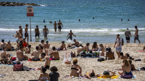 ARCHIVO. La gente juega al fútbol en la playa de Tel Aviv durante un día soleado.