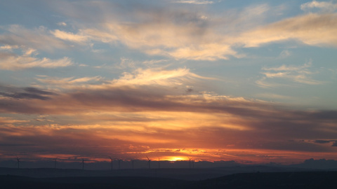 Un cielo con el sol atardeciendo entre nubes.