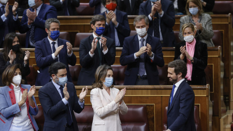 El presidente del PP, Pablo Casado, recibe los aplausos de varios diputados de su partido tras su intervención y momentos antes de abandonar el hemiciclo durante la sesión de control al Gobierno.