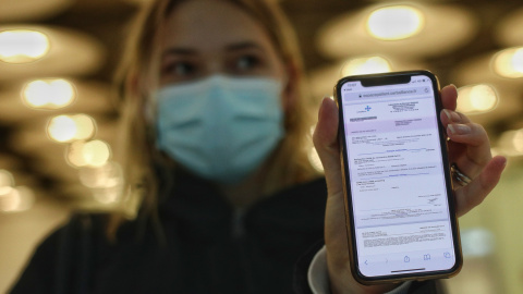 Una mujer de nacionalidad francesa enseña el negativo de su PCR en la terminal T4 del Aeropuerto de Madrid-Barajas Adolfo Suárez, en Madrid (España),