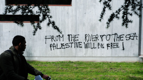 Un ciudadano francés frente a una pintada que dice: "Desde el río hasta el mar, Palestina vencerá", a 30 de abril de 2024.