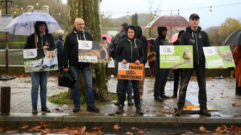 Manifestantes contra la caza sostienen pancartas durante una marcha blanca para rendir homenaje al joven, un año después de que fuera asesinado por un cazador, en Cajarc