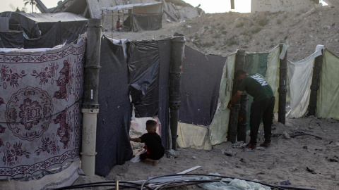 Un palestino desplazado y su hijo en el campamento de Khan Yunis.