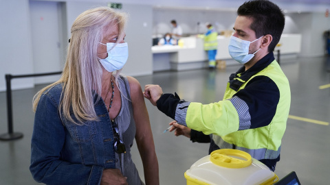 Un sanitario vacuna a una mujer con la dosis de Pfizer, en el Wanda Metropolitano, a 19 de mayo de 2021, en Madrid