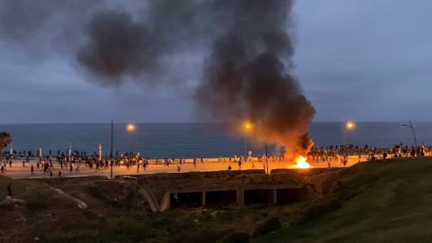 Decenas de emigrantes se encuentran en la entrada de Fnidq (Castillejos), Marruecos, a unos dos kilómetros al sur del Tarajal, donde se están enfrentando con los antidisturbios marroquíes.