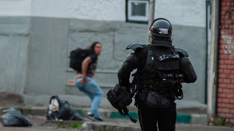 Un policía antidisturbios persigue a un manifestante durante una protesta contra el proyecto de ley de reforma fiscal propuesto por el gobierno de Colombia.