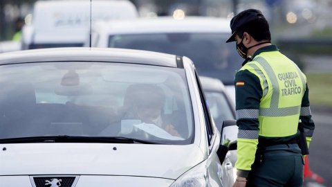 Un agente de la Guardia Civil le pide la documentación al conductor de un vehículo durante un control efectuado en Laredo, Cantabria