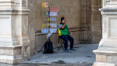 Un vendedor de la ONCE se resguarda en el "Arquillo" del ayuntamiento para protegerse de la lluvia. Sevilla a 18 de septiembre 2020. Foto de Archivo